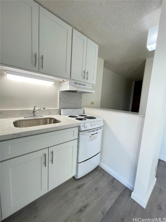 kitchen featuring sink, hardwood / wood-style floors, a textured ceiling, white cabinets, and white electric stove