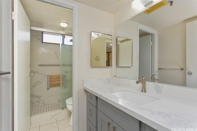 full bath featuring a marble finish shower, visible vents, toilet, and vanity