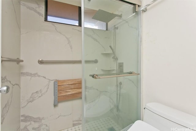 bathroom featuring a marble finish shower and toilet