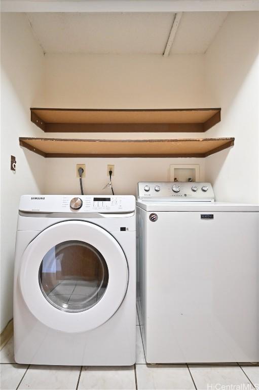 laundry room with light tile patterned floors, laundry area, and washing machine and dryer