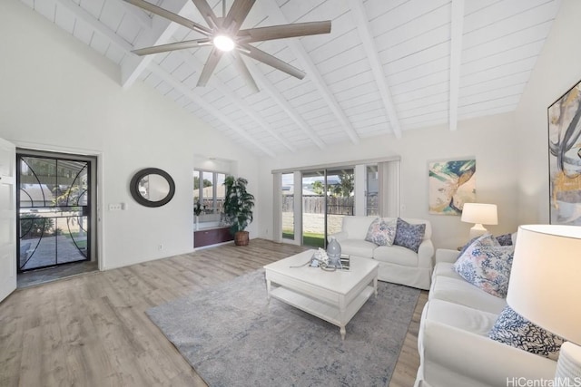 unfurnished living room with high vaulted ceiling, hardwood / wood-style floors, and beam ceiling