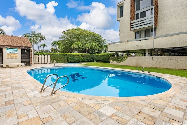 community pool featuring a patio area and fence