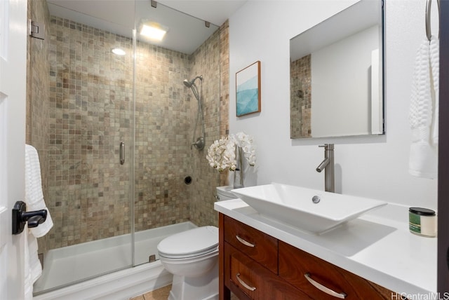 bathroom with vanity, toilet, and a stall shower