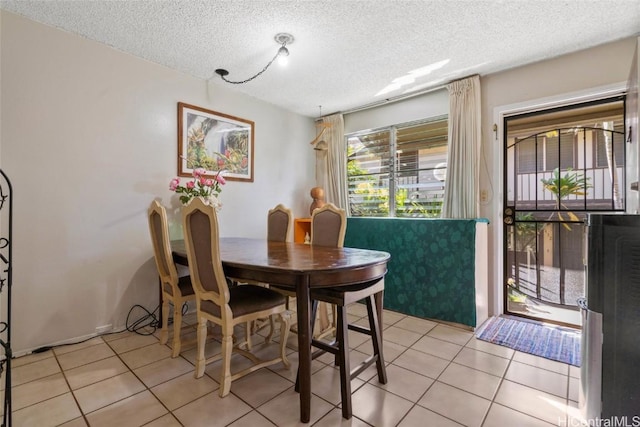 tiled dining space featuring a textured ceiling