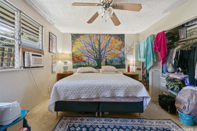 bedroom featuring carpet floors, cooling unit, ceiling fan, a textured ceiling, and a closet