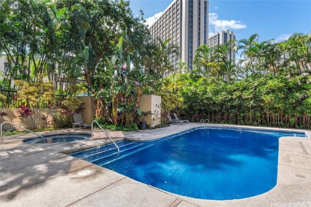 view of swimming pool featuring an in ground hot tub