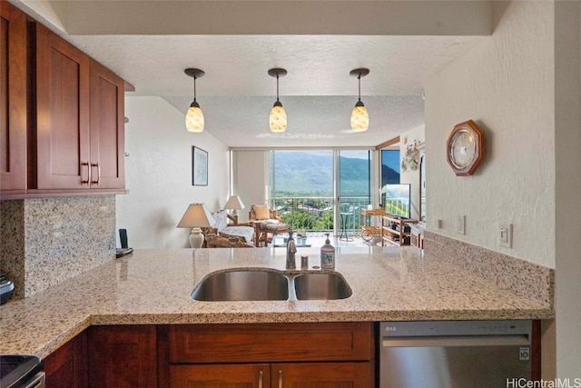 kitchen featuring appliances with stainless steel finishes, sink, pendant lighting, and a textured ceiling