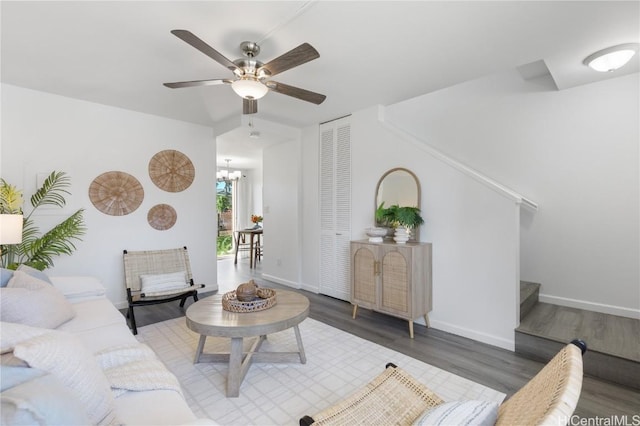 living room with dark hardwood / wood-style floors and ceiling fan with notable chandelier