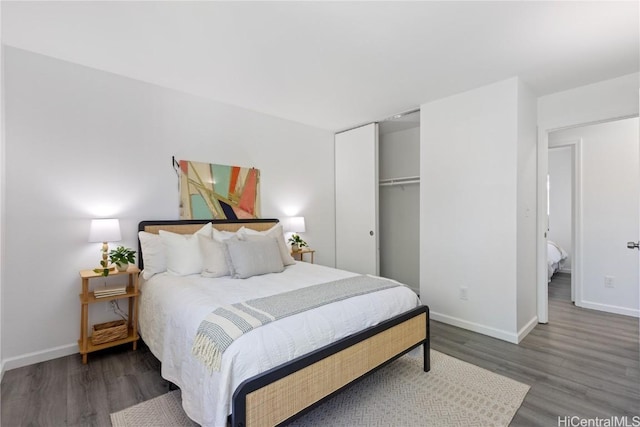 bedroom with dark hardwood / wood-style floors and a closet