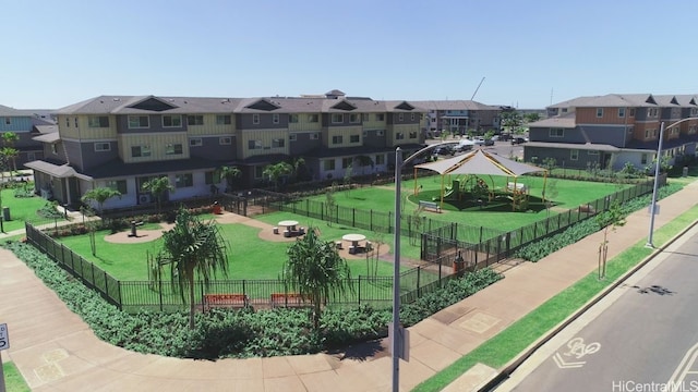 view of property's community with a yard, a residential view, and fence
