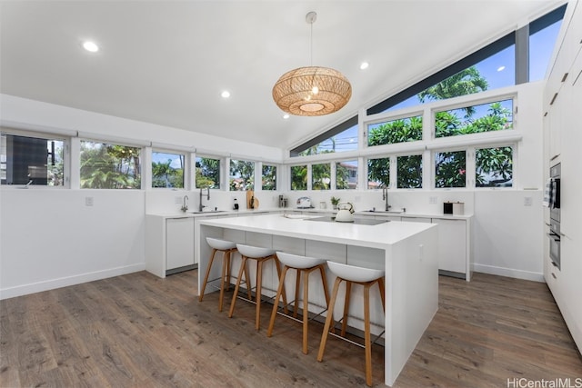 kitchen featuring pendant lighting, sink, a center island, and white cabinets