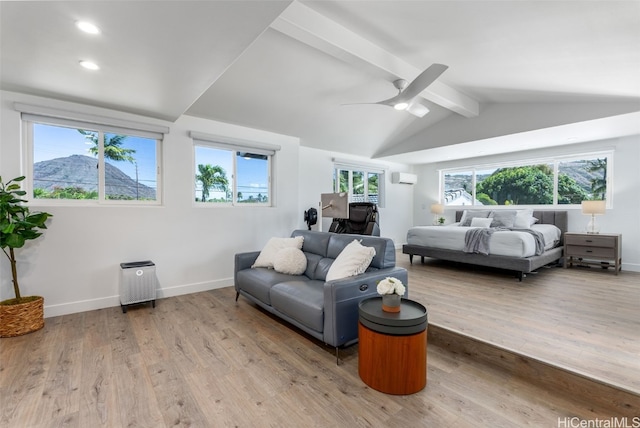 bedroom featuring vaulted ceiling with beams, ceiling fan, a mountain view, a wall unit AC, and light hardwood / wood-style flooring