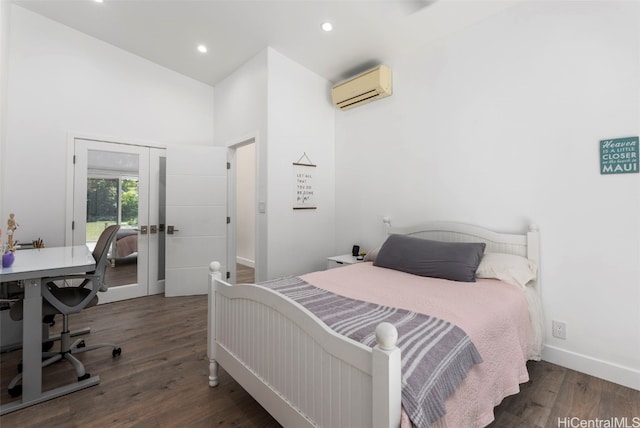 bedroom featuring a wall mounted air conditioner, dark wood-type flooring, and french doors