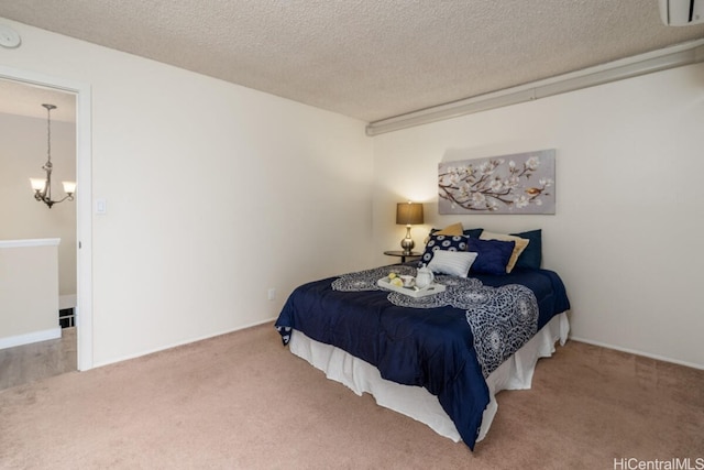 carpeted bedroom featuring a chandelier and a textured ceiling