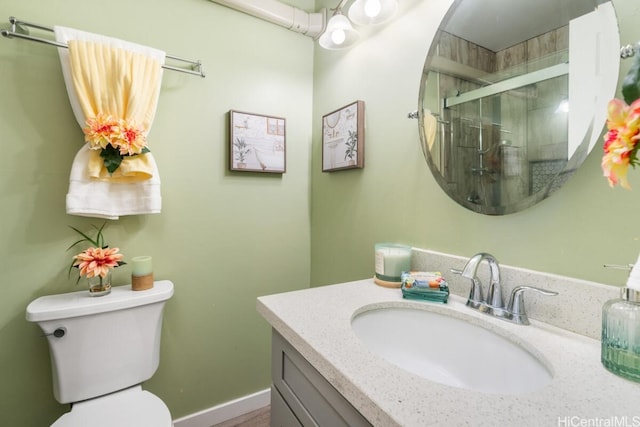full bathroom with a stall shower, vanity, and toilet