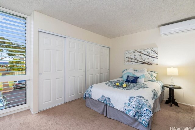 carpeted bedroom featuring a textured ceiling, a closet, and a wall mounted air conditioner