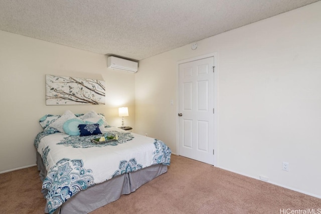 bedroom featuring a wall unit AC, a textured ceiling, and carpet flooring