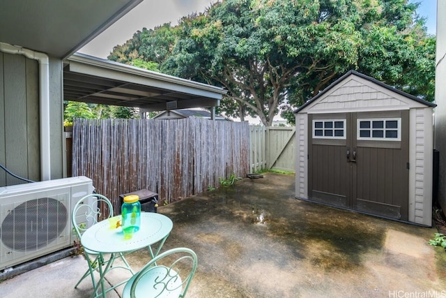 view of patio with ac unit, a fenced backyard, an outbuilding, and a storage unit
