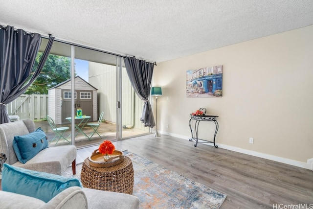 sitting room featuring a textured ceiling, wood finished floors, and baseboards