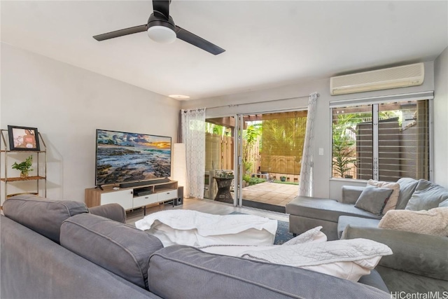 living room with a wall mounted air conditioner, wood-type flooring, and ceiling fan