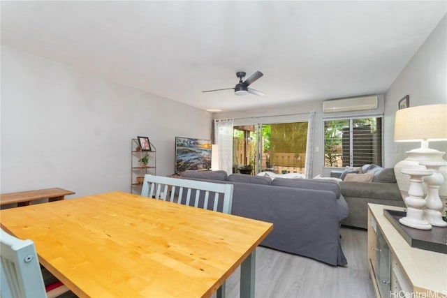 dining area featuring ceiling fan, light wood-type flooring, and a wall unit AC