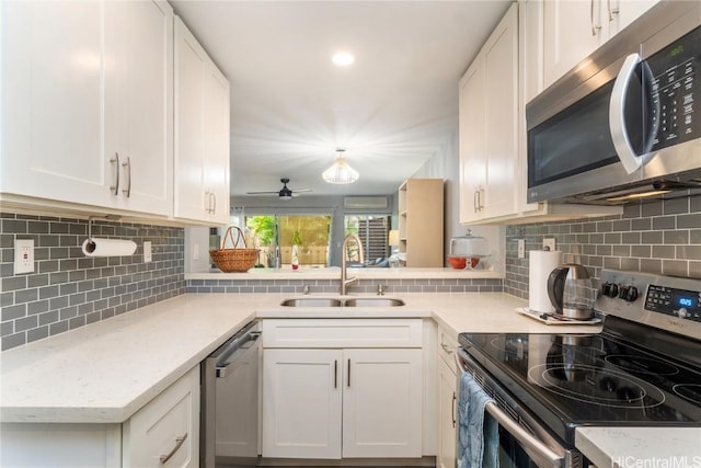 kitchen with stainless steel appliances, sink, white cabinets, and decorative backsplash