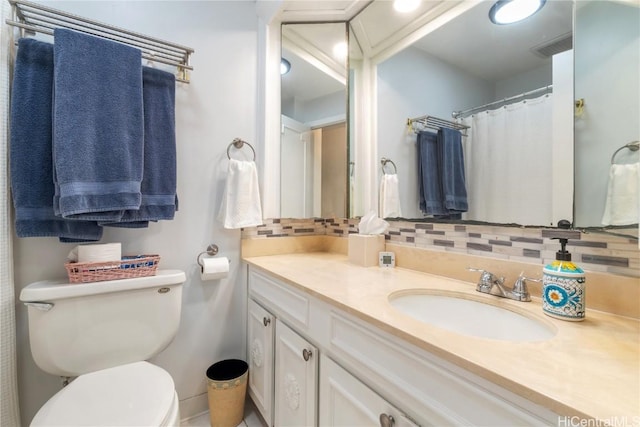 bathroom with vanity, toilet, and decorative backsplash