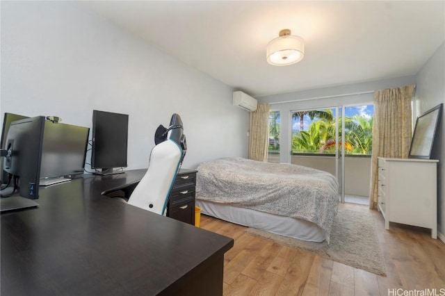 bedroom with a wall unit AC and light wood-type flooring