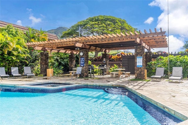 view of swimming pool with a community hot tub, a patio area, grilling area, a pergola, and a mountain view