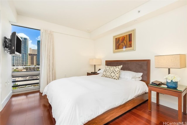 bedroom featuring access to exterior, baseboards, and wood finished floors