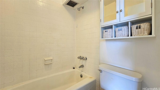 bathroom featuring toilet and tiled shower / bath