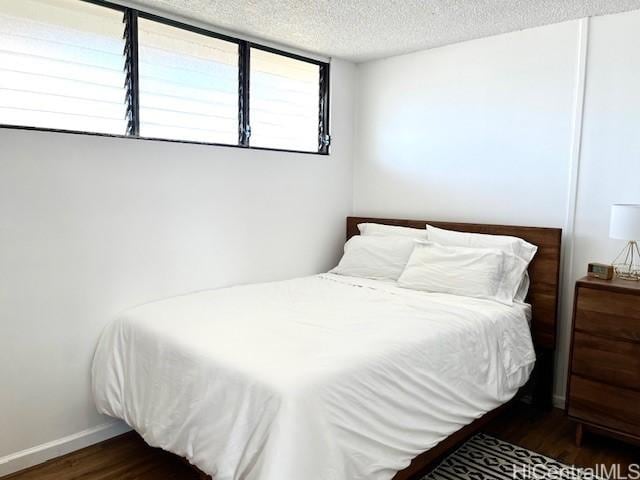 bedroom featuring dark hardwood / wood-style floors and a textured ceiling