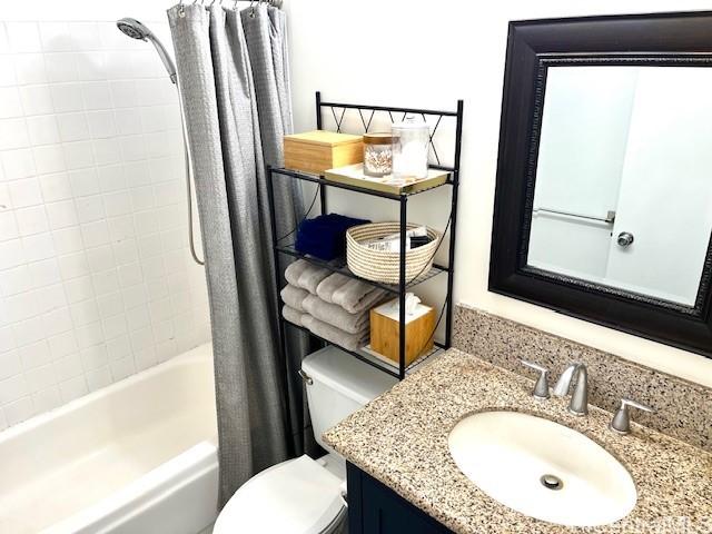 full bathroom with toilet, vanity, and shower / bath combo with shower curtain