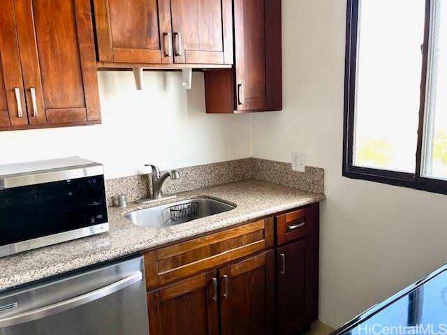 kitchen with light stone counters, sink, and stainless steel appliances