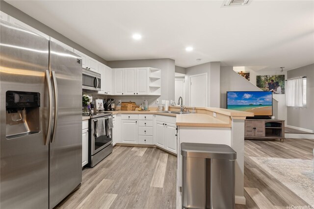91-338 Makalea St Unit 52, Ewa Beach, HI 96706 - kitchen with stainless steel appliances, a peninsula, light wood finished floors, white cabinets, and recessed lighting