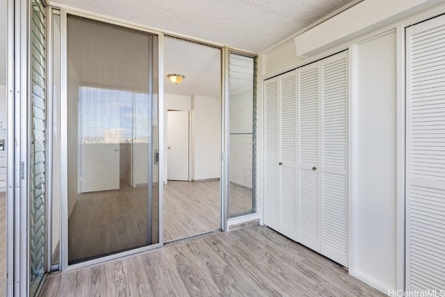 unfurnished bedroom with a textured ceiling and light hardwood / wood-style flooring