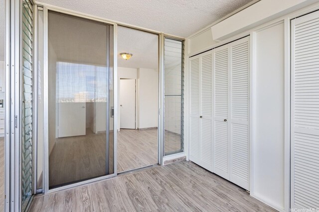1617 Clark St Unit 702, Honolulu, HI 96822 - unfurnished bedroom with light wood-style floors and a textured ceiling