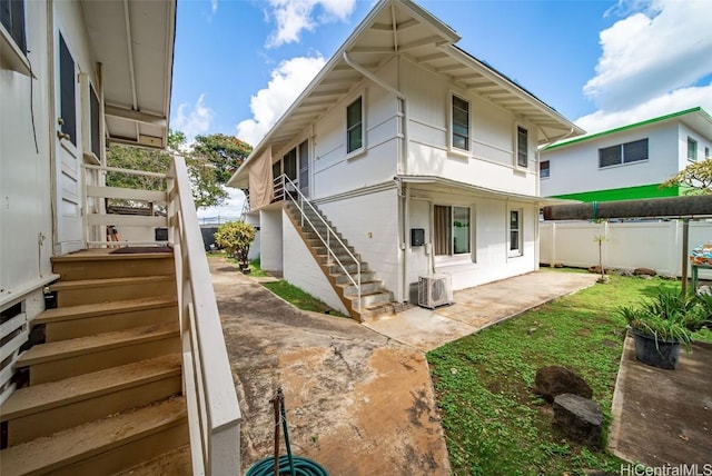 rear view of house with a patio, stairway, fence, and ac unit