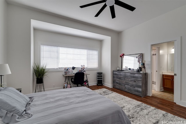 bedroom with ensuite bath, dark hardwood / wood-style floors, and ceiling fan