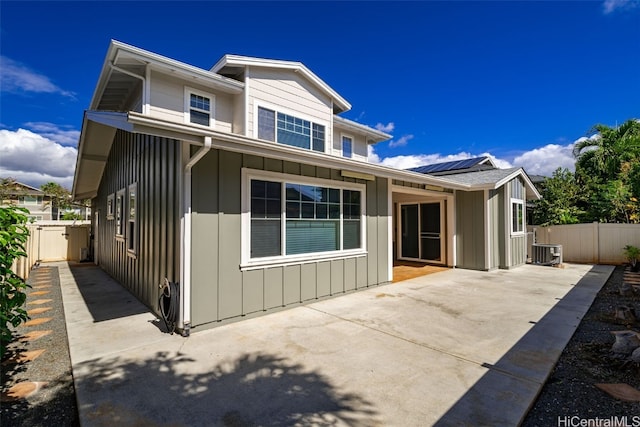 view of front of home with a patio, cooling unit, and solar panels