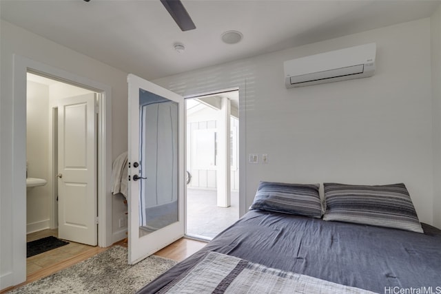 bedroom with ceiling fan, light hardwood / wood-style floors, and a wall mounted AC