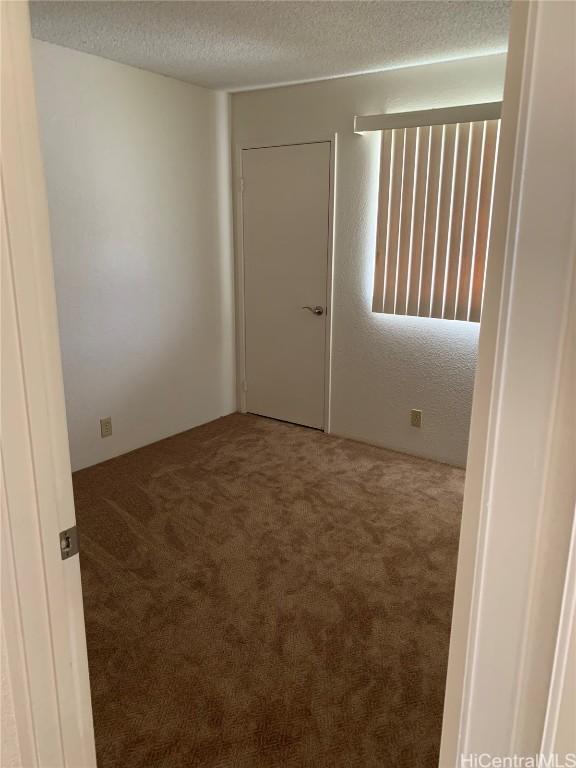 spare room with a textured ceiling and carpet flooring