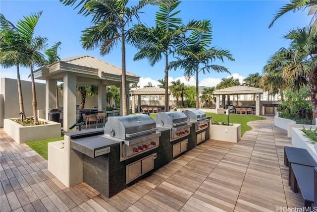 view of patio featuring exterior kitchen, a gazebo, and area for grilling