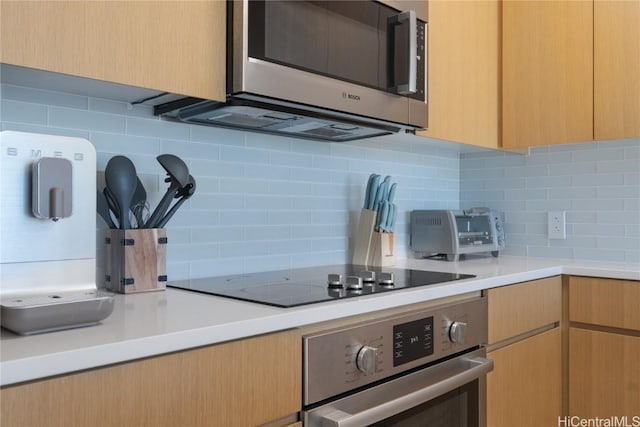 kitchen featuring stainless steel appliances and decorative backsplash