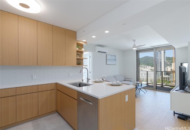 kitchen with sink, a wall of windows, kitchen peninsula, stainless steel dishwasher, and an AC wall unit