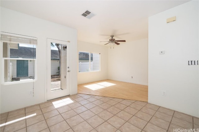 tiled empty room featuring ceiling fan