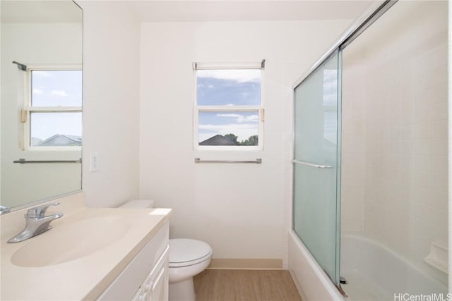 full bathroom featuring vanity, shower / bath combination with glass door, and toilet