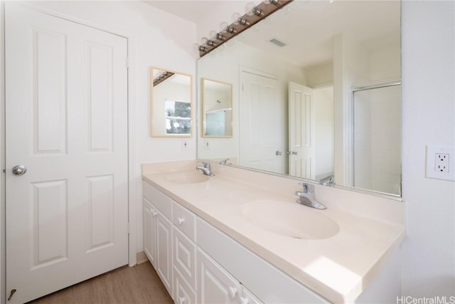 bathroom featuring hardwood / wood-style flooring, vanity, an enclosed shower, and toilet