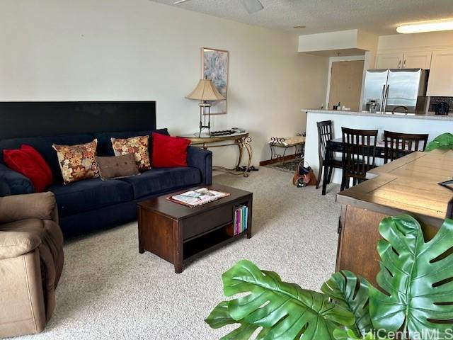 living room featuring light carpet and a textured ceiling