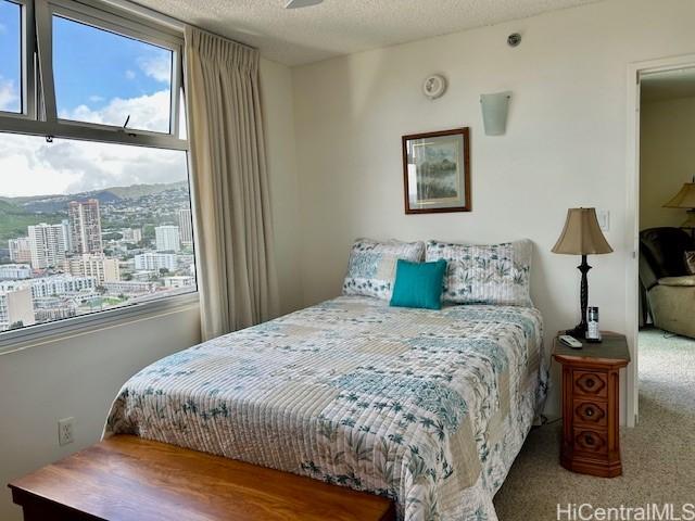 bedroom with carpet floors and a textured ceiling